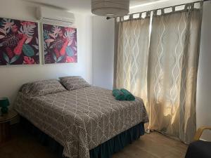 El SunzoPENTHOUSE EN MONTERRICO的一间卧室配有床和带窗帘的窗户