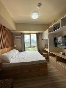 宿务IT Park Cebu City (Avida Riala)的一间卧室设有一张大床和一个窗户。