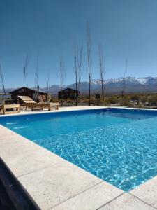 乌斯帕亚塔cabañas de montaña的一个大型蓝色游泳池,后面是群山