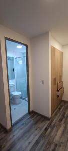 波哥大86 suites的一间空浴室,内设卫生间和玻璃门