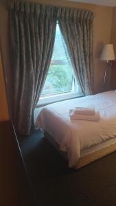 伦敦赛古酒店的一间卧室设有一张床和一个窗口