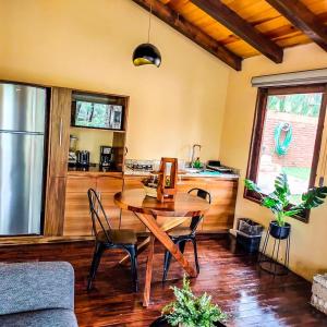 马萨米特拉Cabañas Las Morenas Mazamitla的一间带木桌的客厅和一间厨房