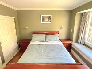 温哥华Elegant, Sunny Modern Home with Skylights - Kitsilano, Vancouver的一间卧室配有一张带木制床头板的床