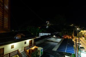 圣安东尼奥-杜皮尼亚尔Pousada Alemã的屋顶上设有太阳能电池板的建筑的夜景