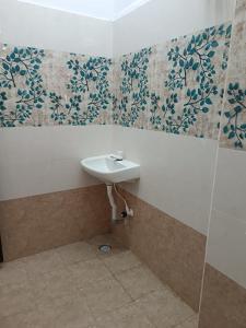 蒂鲁帕蒂SGS Residency的墙上装饰有花卉壁纸的带水槽的浴室