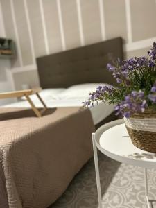 塔兰托Casa la cava的一间卧室配有一张床和一张紫色花卉桌子
