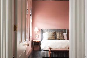 查尔斯顿The Juliette - Luxury Historic Residence的一间卧室配有一张粉红色墙壁的床