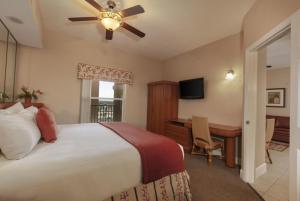 奥兰多Kay's Sweet Suite Near Disney的一间卧室配有一张床、一张桌子和吊扇