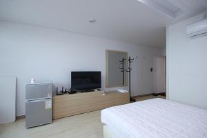 巨济VIEW Hotel Geoje的一间卧室配有一张床和一台平面电视