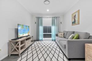 Banksia BeachOSPREY ISLAND RETREAT的客厅配有灰色的沙发和电视