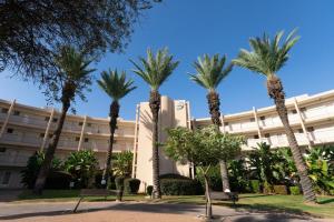 凯撒利亚lasuita- exclusive suites cesarea- sea view suite的一群棕榈树在一座建筑前