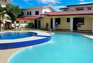 CangbaliguiaRedDoorz at Carlton-Martin Hotel Masbate City的一座大蓝色游泳池,位于房子前
