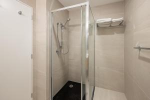 奥克兰Manha Hotel Auckland Airport的浴室里设有玻璃门淋浴
