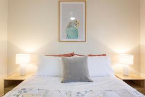 珀斯Casa Toucan - 2 bedroom apartment close to the airport的一间卧室配有一张带两盏灯的床