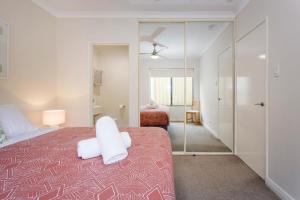 珀斯Casa Toucan - 2 bedroom apartment close to the airport的一间卧室配有一张床和镜子