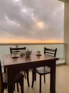 贾埃勒MaSa Beach Front Apartment Uswetakeiyawa的一张木桌和椅子,享有海景