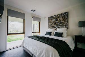 凯恩顿Park Crescent - Daylesford Macedon Region的一间卧室设有一张大床和一个大窗户