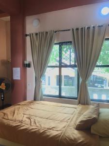 庞卡兰布翁Bubuhan Kita Guest House Syariah的一间卧室设有一张大床和一个窗户。