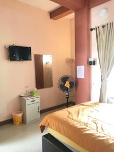 庞卡兰布翁Bubuhan Kita Guest House Syariah的一间卧室配有一张床、镜子和电视