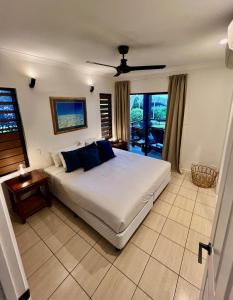 汉密尔顿岛昂克拉吉尔酒店的卧室配有带蓝色枕头的大型白色床