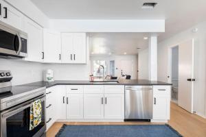 奥斯汀2 Bedroom East Riverside Home with Garage-Sleeps 6的厨房配有白色橱柜和不锈钢洗碗机。