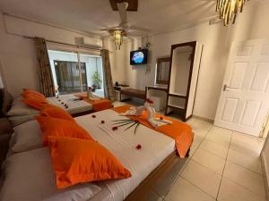 拉迪格岛经典别墅酒店的客厅配有两张带橙色枕头的床