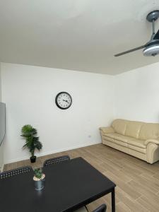 帕斯特伦戈Appartamenti Chapò的客厅配有沙发和墙上的时钟