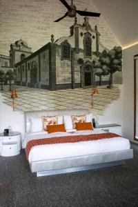 瓦加托W果阿度假村的一间卧室配有两张床,墙上挂着一幅画