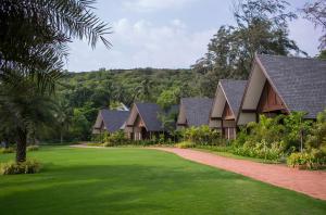 瓦加托W果阿度假村的一排房子,有绿色的院子