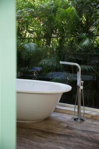 瓦加托W果阿度假村的浴缸位于窗户前