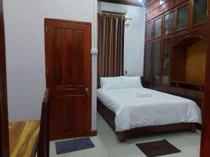 万荣Inthavong Hotel/Guest House的一间带床和木柜的小卧室