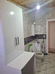 伊斯坦布尔İstanbulun merkezinde lüx 2 odalı daire的一间带白色橱柜和卫生间的浴室
