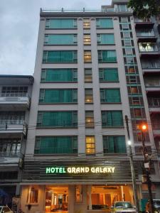 仰光Hotel Grand Galaxy的一座大卡加里建筑,上面有标志