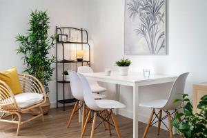 塞维利亚Magno Apartments Miño的一间配备有白色桌椅的用餐室