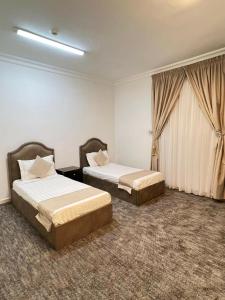 麦地那غزالي للوحدات السكنية的酒店客房设有两张床和窗户。