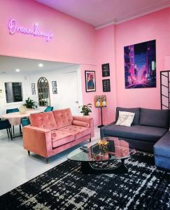 墨尔本Dreamhouse的客厅设有粉红色的墙壁和粉红色的沙发