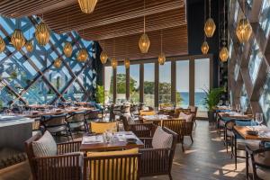 长滩岛绯红度假酒店&Spa长滩岛的餐厅设有桌椅和大窗户。