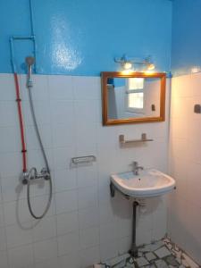 AbéméKONE-METTLER GUEST HOUSE的浴室配有盥洗盆和带镜子的淋浴