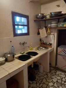 AbéméKONE-METTLER GUEST HOUSE的厨房配有两个水槽和台面