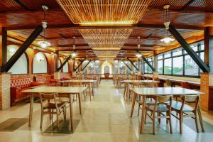 清迈WangChang Hotel Chiang Mai โรงแรมวังช้าง เชียงใหม่的用餐室设有桌椅和窗户。