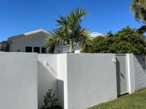 拜伦湾Sunny Palm Cottage Byron Bay - Brand New的房屋前有门的白色围栏