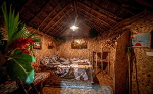 The Asaro Mudmen Tribal Eco Lodge的一间设有床铺和沙发的房间