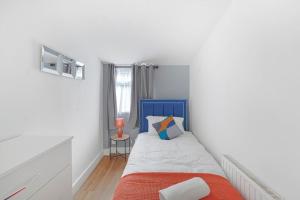 埃德蒙顿The Marsden - Modern 3 bed, Virgin TV, WIFI的卧室配有蓝色和白色的床和窗户。