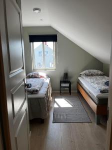阿伦达尔Cozy and new apartment in Arendal -Hill的客房设有两张床和窗户。