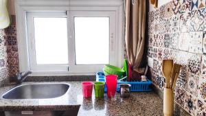 达哈布Dahab Relax Studio 3的厨房水槽,柜台上设有红绿杯