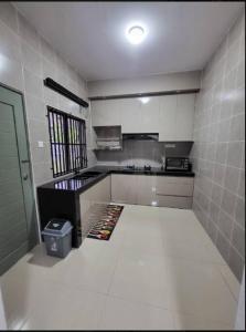 淡马鲁Q Homestay @ Temerloh的厨房铺有白色瓷砖墙壁和白色地板。