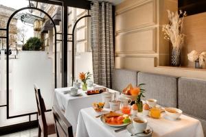 巴黎伊特莱尔辉煌饭店的用餐室配有2张桌子和食物