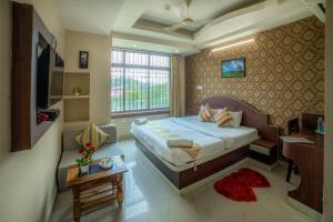 古瓦哈提Asian Suites Guwahati的一间卧室配有一张床和一张沙发