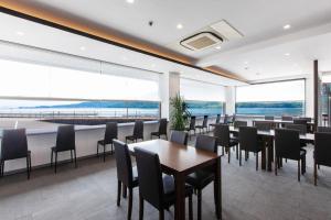 廿日市Global Resort Misen - グローバルリゾート弥山的用餐室配有桌椅和大窗户