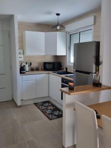 阿维尼翁maison cosy avec petit jardin的厨房配有白色橱柜和不锈钢冰箱